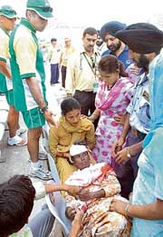 South African team’s doctor Moosajee Mohammad (second from left) watches the labourer who had an epileptic attack at the PCA Stadium in Mohali on Thursday.