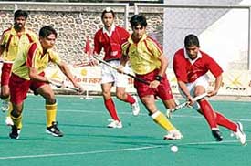 Punjabs Jarnail Singh (right) gets past a Karnataka player during a knockout match of the 62nd National Hockey Championship at the Olympian Surjit Hockey Stadium in Jalandhar on Thursday. 