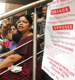 Bank employees under the banner of United Forum of Bank Unions sit in dharna to protest against the anti labour policies of the central government during the nation-wide strike at Parliament Street in New Delhi on Friday