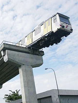 A derailed carriage of Malaysias Star light rail transit system hangs from a raised track in Kuala Lumpur