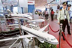 Securiry officers walk past models of passenger planes displayed at the 6th China International Aviation and Aerospace Exhibition in Zhuhai on Monday.