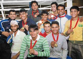 Boxers show their medals won during the Panjab University inter-college boxing meet held at the PU gymnasium hall on Monday. 