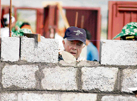 Former US President Jimmy Carter builds a house as part of the 23rd Jimmy Carter project in Patan village near Pune on Monday. 