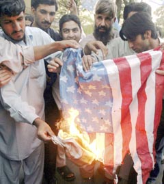 Activists of Muttahida Majlis-e-Amal burn a US flag during a protest held in Islamabad on Tuesday to condemn an army attack on a religious school in the Chenagai area of the Bajaur tribal region