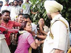 Police personnel push back the protesting relatives of a missing boy outside the division police station in Amritsar on Thursday. 