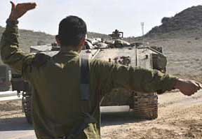 An Israeli soldier directs an armoured personnel carrier near Kibbutz Erez, just outside the northern Gaza Strip, on Thursday. Israeli forces backed by tanks killed four Palestinians in northern Gaza on Thursday as the army pressed on with one of its biggest operations in the strip in months.
