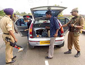 Policemen search a car at a checkpoint outside the international airport in Thiruvanathapuram on Thursday. 