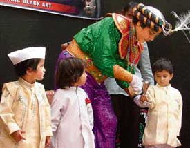 Mogembo, famous magician, performs tricks with little children on Childrens Day celebrated in St Xaviers School