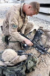A Canadian soldier of 2nd Princess Patricas Canadian Light Infantry, inspects weapons in Kandhar province