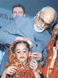 Former Prime Minister I. K. Gujral distributing hearing aids at a function in the Capital on Friday. 