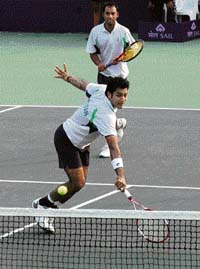 Pakistans Aisam-ul-Haq Qureshi plays a shot as his partner Aqeel Khan looks on during the doubles match against Indias Rohan Bopanna and Mustafa Ghouse