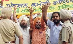 Members of Sugar Mills Workers Union protest in front of Co-operative Minister Amarjit Singh Samra's house in Jalandhar