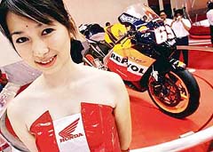 An exhibitor stands before a Honda sports bike at the Jakarta Motor Show 2006 in Jakarta 