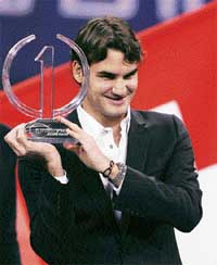 Switzerlands Roger Federer holds the Indesit ATP trophy at an awards ceremony in Shanghai on Monday. Federer won the trophy for the third successive year after finishing the season as the world number one.