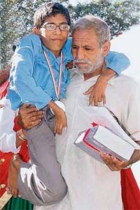 Fatehabad topper Sheetal Das being carried back to his seat by his father after receiving an award from the Haryana Chief Minister at a function held at the CMs residence in Chandigarh