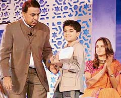 Sunil Gavaskar presents a bat to a child at the launch of special edition of Sunil Gavaskar and Sania Mirza Credit Cards by Deutsche Bank in New Delhi