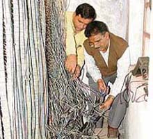 Railway employees repair wires that control signals near the Lakkar bridge in Ludhiana