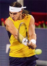 Spains Rafael Nadal hits a return to Russiaa Nikolay Davydenko during a round-robin match of the Masters Cup in Shanghai on Friday.