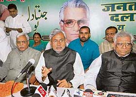 Bihar Chief Minister Nitish Kumar announces the joining of RJD leaders Shivanand Tiwari (left) and Bhola Yadav (right) with the JD(U) at the state party head office in Patna