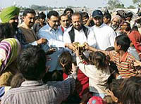 Mr K.K. Bawa, Chairman, Housefed, Punjab, and others distribute fruits in the slum areas to mark the birth anniversary of Ms Indira Gandhi in Ludhiana on Sunday.