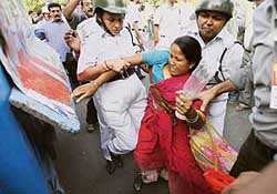 Policewomen try to stop a Left demonstrator from breaking a cordon