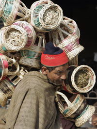 A vendor carries Kashmiri traditional firepots called kangris