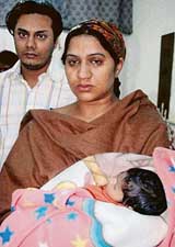 Mrs Harinder Kaur holds her 16-day-old daughter, who underwent a landmark cardio-vascular surgery successfully, in the PGI, Chandigarh. Mr Harcharan Singh, father of the girl, is also seen in the picture. 