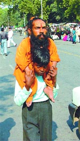Chote Baba, 40-year-old Sadhu being helped by a 14-year-old child to catch the public transport