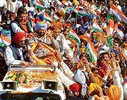 People shower flower petals on Punjab Chief Minister Amarinder Singh during Vikas Yatra at Batala on Friday. 