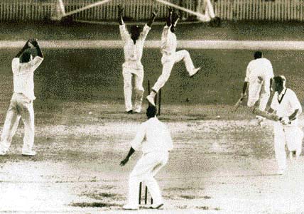West Indian players celebrate as tailender Ian Meckiff is run out by Joe Solomon, preventing Australia from scoring the winning run