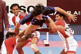 Rakesh Kumar of India (centre) leaps in the air to try and score a point against Bangladesh in the first round of kabaddi in Doha on Saturday. 