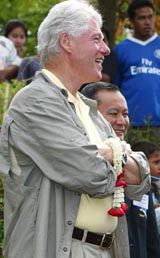 Former US President Bill Clinton looks on during his visit to a Thai gypsy village damaged by the tsunami in 2004 in Phuket, Thailand, on Saturday