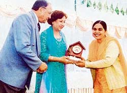Ms Malkiat Kaur, Headmistress, Government Girls High School, Ramgarh (Ludhiana), receives an award of honour from the Punjab Governor and his wife