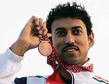 Rajyavardhan Singh Rathore poses on the podium with his bronze medal after the double-trap final in Doha on Tuesday. 