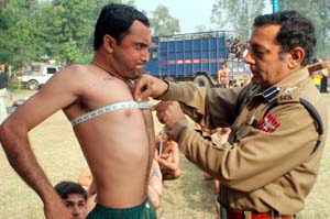 A police officer measures the chest of a youth during a recruitment rally organised by the Jammu and Kashmir police in Jammu on Thursday.