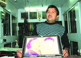 Father Kamal Kishore Kanojia with a picture of his two slain children Heena and Abshishek at his drycleaning shop in Jalandhar