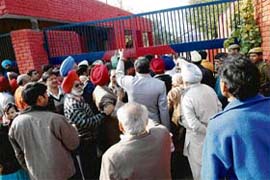Family members of detained schoolteachers wait in front of Model Burail Jail, Chandigarh
