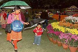 Visitors take shelter under umbrellas after a drizzle at Terraced Garden, Chandigarh