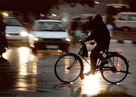A cyclist makes his way in the slow traffic due to heavy rain in Chandigarh