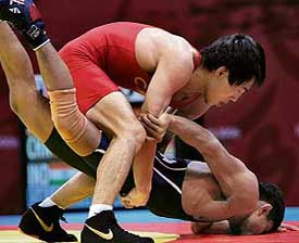 Chinas Jiao Huafeng brings down Indias Vinayak Dalvi during their 55 kg Greco-Roman wrestling quarterfinal on Sunday