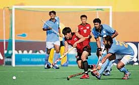 South Koreas You Hyo-sik gets past Indias Rajpal Singh during a mens hockey pool match in Doha on Sunday