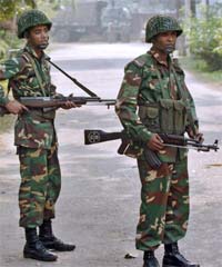 Bangladeshi army soldiers stand guard at the entrance of their temporary camp in Dhaka