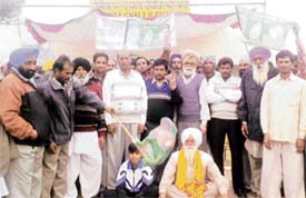Office-bearers of the RJD pose with residents after a function to mark the resumption of stoppage of trains at Rohira near Ahmedgarh