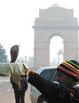 A snake charmer draws a crowd of curious onlookers at India Gate on Wednesday