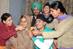 Celebration time in the family of Manjeet Kaur Saini, who won the gold medal in 4X100m relay race in the Doha Asian Games, at Jalandhar on Wednesday.