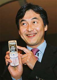 Senior Vice-President and Managing Director of Multimedia services at NTT DoCoMo Inc. Takeshi Natsuno displays live video feed on his mobile phone in New Delhi