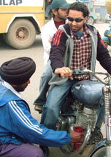 A traffic police constable removs a pressure horn from a bike in Amritsar.