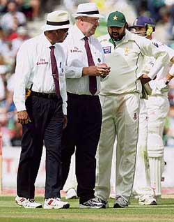 Umpires Billy Doctrove (left) and Darrell Hair show the doctored ball to Pakistans captain Inzamam-ul-Haq during the fourth Test between Pakistan and England at the Oval cricket ground in London on August 20. 