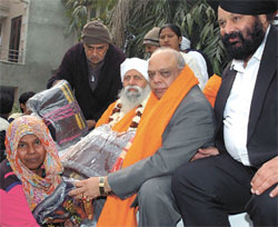 Delhi Minister of Industry and Labour Mangat Ram Singhal distributing blankets to the poor in the Capital on Friday.