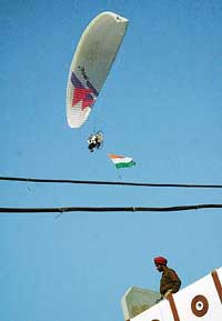 Paraglider Bhupinder Singh Chitrakaar drops leaflets on the Vikas Yatra of Chief Minister Amarinder Singh at Barnala on Friday. 